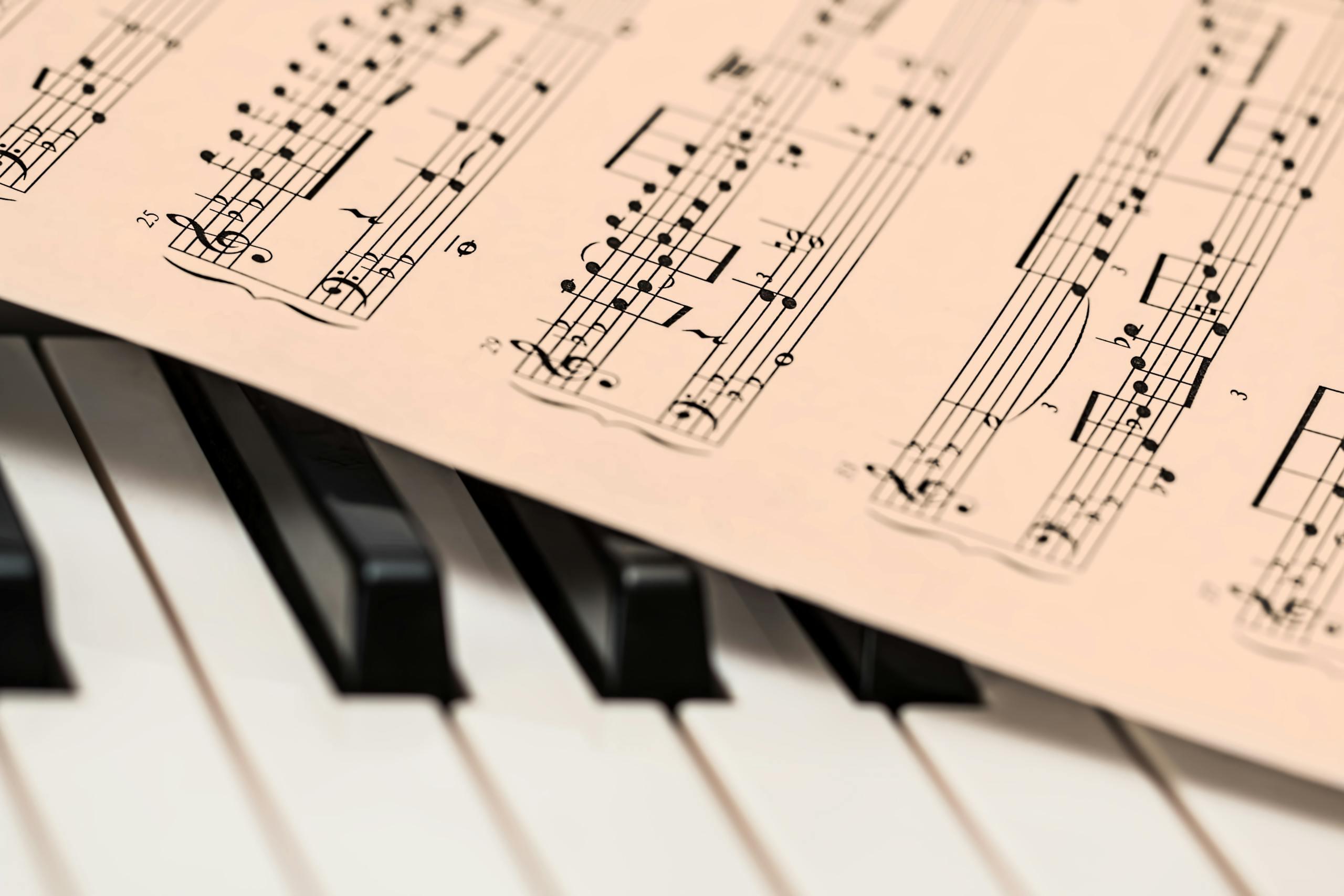 Black and white piano keys with a sheet of classical music creating a harmonious composition.